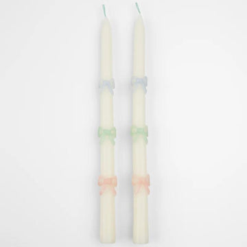 Kaarsen met pastelkleurige strikjes